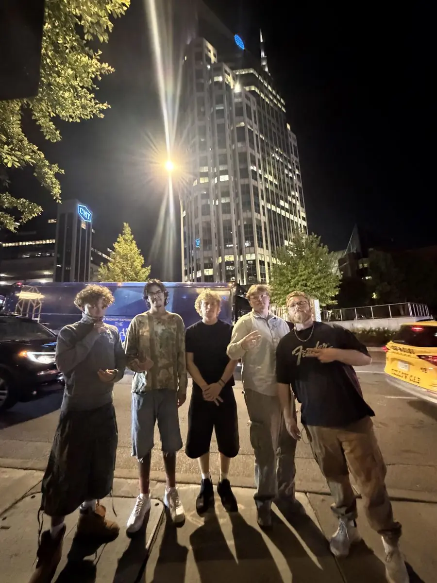 The crew posing under city lights at night